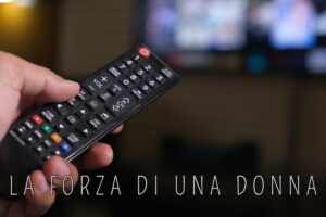 telecomando puntato alla tv e scritta "la forza di una donna"